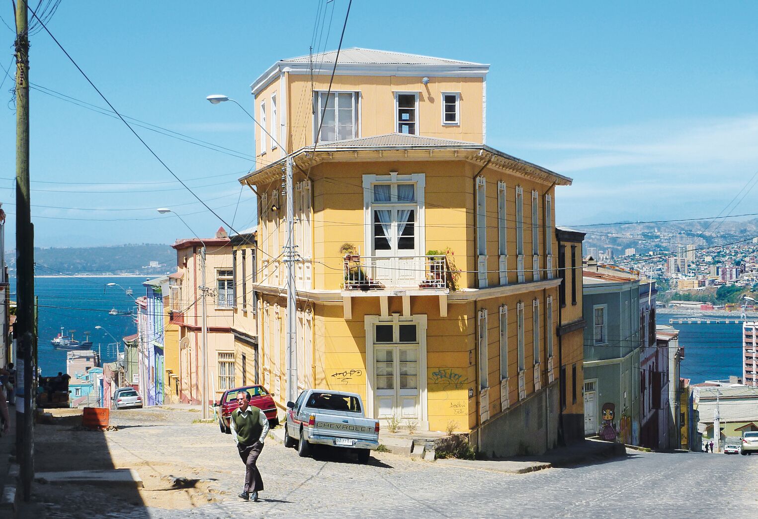 Rue de Valparaiso avec maison jaune et vue sur la mer, au Chili